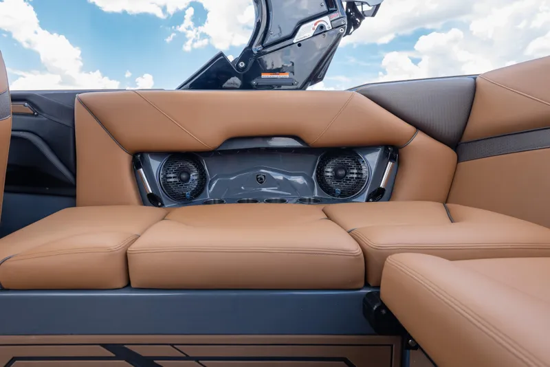 Slide: The Image of 2025 Centurion Nv233 boat interior with tan leather seats and built-in speakers. - 16