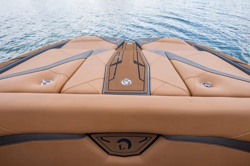 Slide: The Image of 2025 Centurion Nv233 boat deck with tan upholstery on calm water. - 18