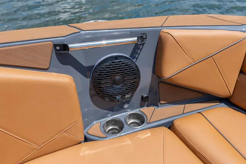 Slide: The Image of 2025 Centurion Nv233 boat interior with tan leather seats, speaker, and cup holders. - 9