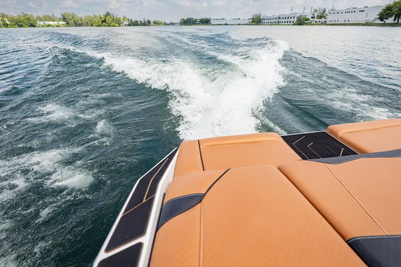 Slide: The Image of 2025 Supreme S220 boat creating waves on a serene lake. - 22