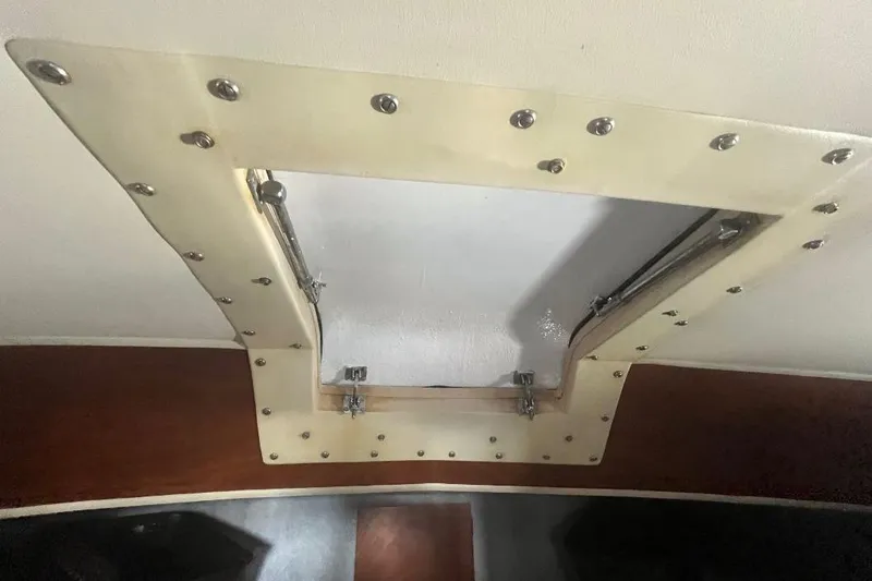 Slide: The Image of 1973 Uniflite Sport Fisher boat interior hatch with metal hinges and screws. - 106