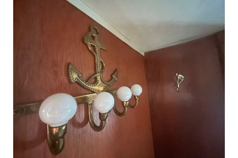 Slide: The Image of 1973 Uniflite Sport Fisher interior with brass anchor and coat hooks on wooden paneling. - 109