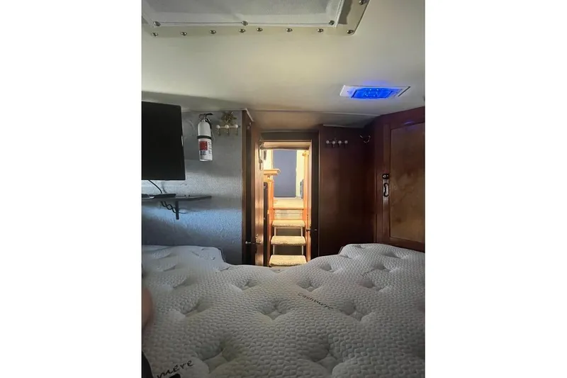 Slide: The Image of 1973 Uniflite Sport Fisher cabin interior with bed, stairs, and fire extinguisher. - 112