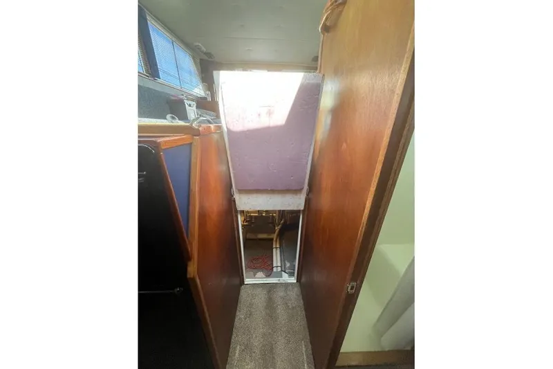 Slide: The Image of 1973 Uniflite Sport Fisher interior with wooden paneling and narrow passageway. - 113