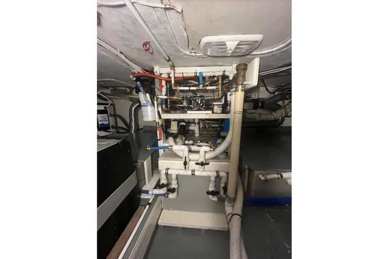 Slide: The Image of Engine room of a 1973 Uniflite Sport Fisher boat, showcasing pipes and machinery. - 114