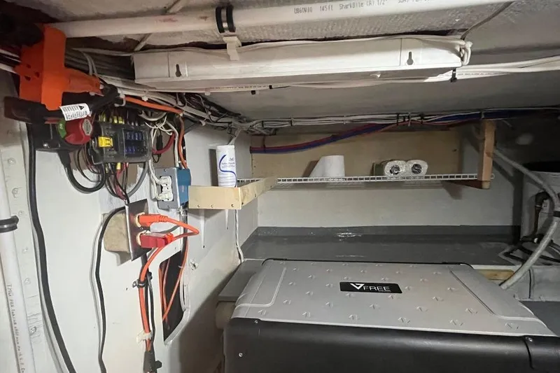 Slide: The Image of 1973 Uniflite Sport Fisher interior wiring and storage area with electrical components and shelves. - 116