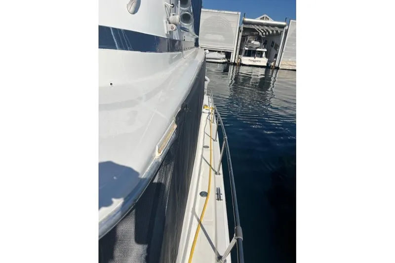 Slide: The Image of 1973 Uniflite Sport Fisher boat docked at marina, side view with water reflection. - 12