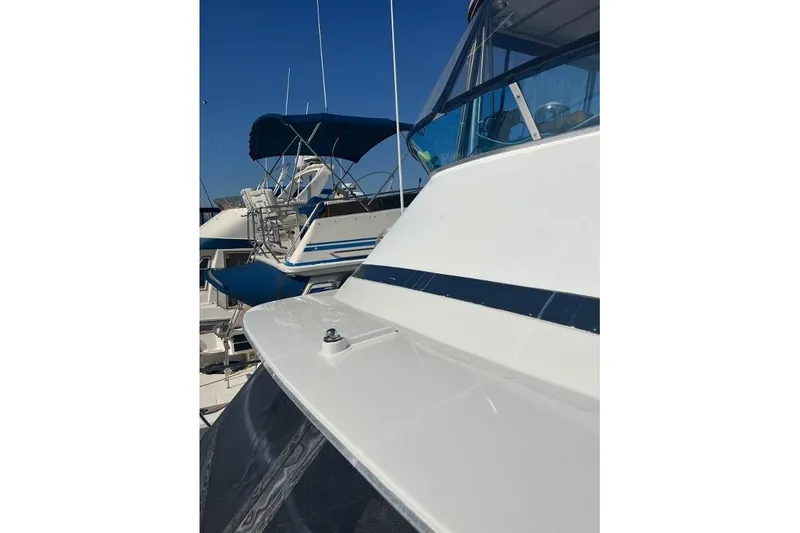 Slide: The Image of 1973 Uniflite Sport Fisher boat docked, featuring sleek white and blue design. - 14