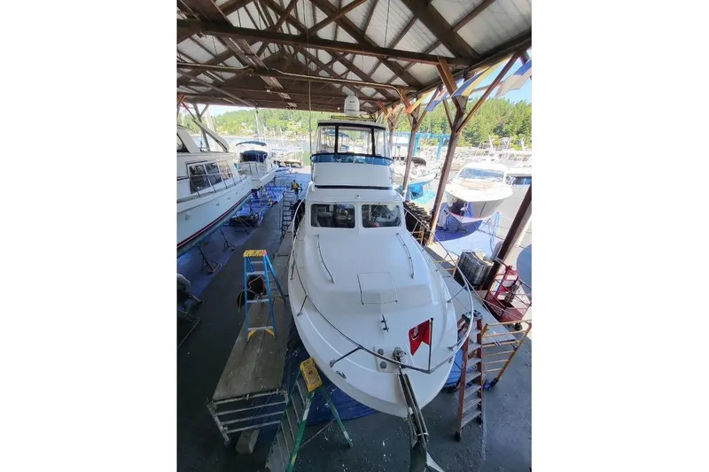 Slide: The Image of 1973 Uniflite Sport Fisher boat in a covered dock, surrounded by other vessels. - 141