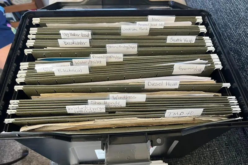 Slide: The Image of Organized file box with labeled folders for 1973 Uniflite Sport Fisher boat documents. - 143