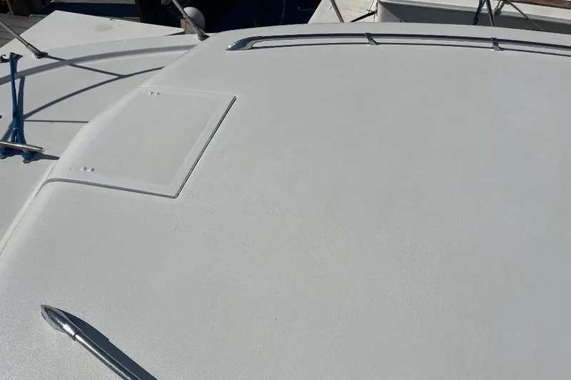 Slide: The Image of 1973 Uniflite Sport Fisher boat deck with railing and hatch, in bright sunlight. - 15