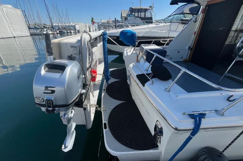 Slide: The Image of 1973 Uniflite Sport Fisher boat docked with outboard motor, marina background. - 18