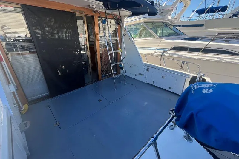 Slide: The Image of 1973 Uniflite Sport Fisher boat deck with ladder and covered equipment. - 24