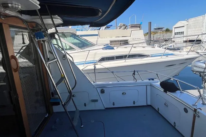 Slide: The Image of 1973 Uniflite Sport Fisher boat docked at marina with clear blue sky. - 25
