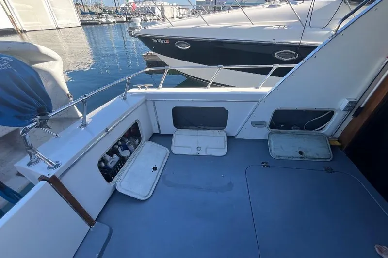 Slide: The Image of 1973 Uniflite Sport Fisher boat deck with storage compartments, docked at marina. - 29