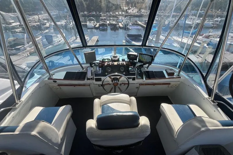 Slide: The Image of 1973 Uniflite Sport Fisher boat cockpit with steering wheel and marina view. - 38