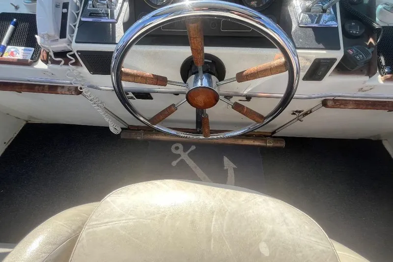 Slide: The Image of 1973 Uniflite Sport Fisher helm with wooden steering wheel and nautical decor. - 42