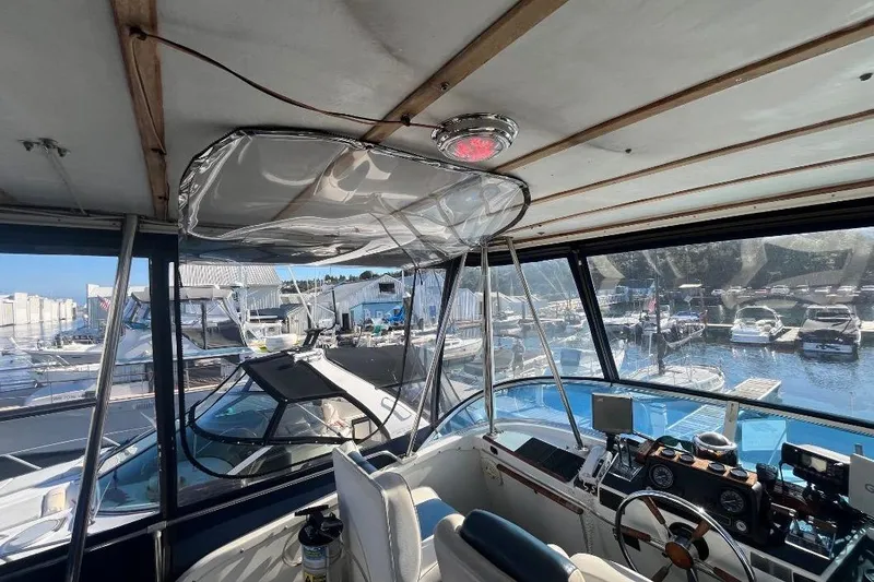 Slide: The Image of 1973 Uniflite Sport Fisher boat interior with marina view, featuring helm and navigation equipment. - 45