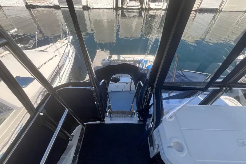 Slide: The Image of 1973 Uniflite Sport Fisher boat interior with marina view, featuring sleek design and water reflections. - 49