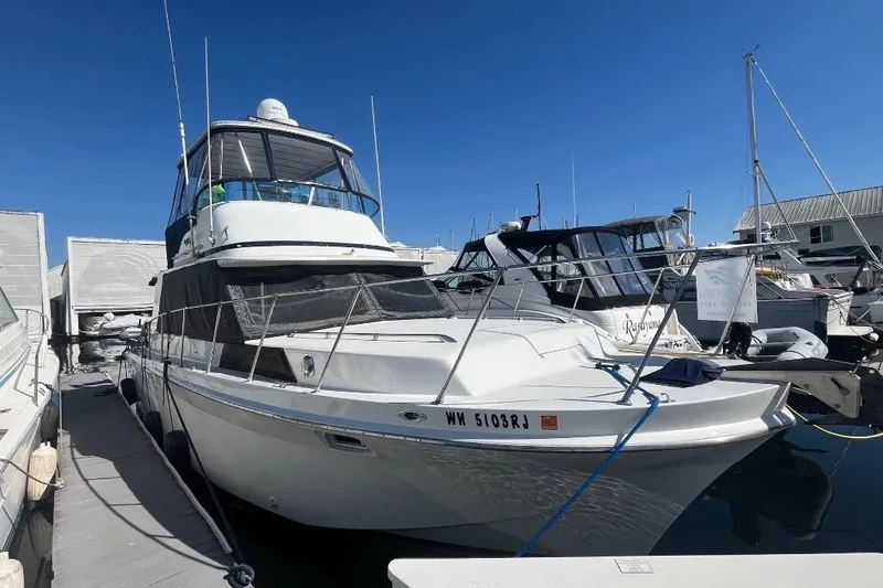 Slide: The Image of 1973 Uniflite Sport Fisher boat docked at marina under clear blue sky. - 5