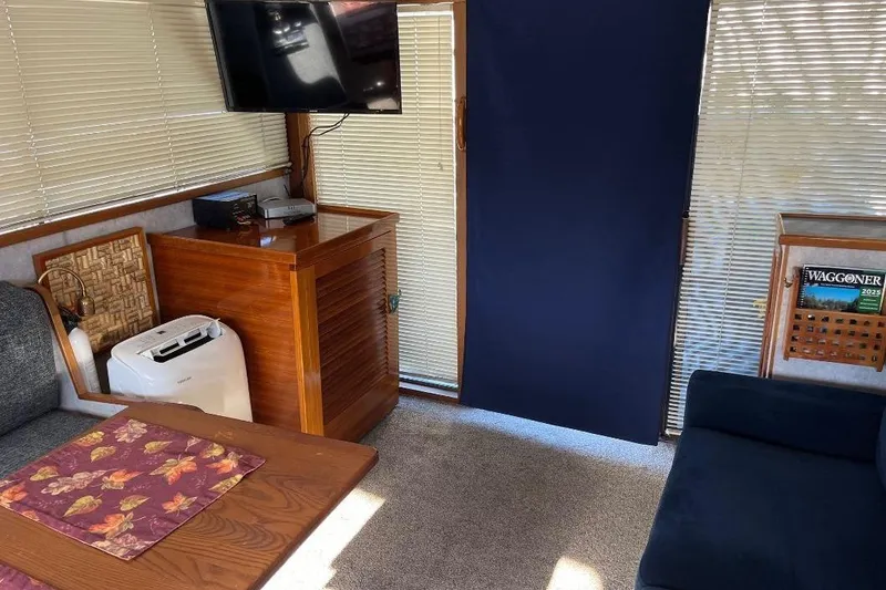Slide: The Image of 1973 Uniflite Sport Fisher interior with TV, wooden cabinet, and cozy seating area. - 53