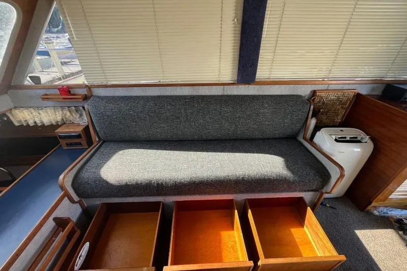 Slide: The Image of 1973 Uniflite Sport Fisher interior with gray sofa and open wooden drawers. - 59