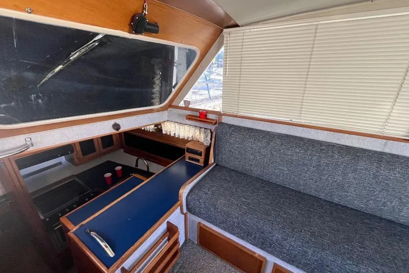 Slide: The Image of 1973 Uniflite Sport Fisher interior with blue counters, gray seating, and window blinds. - 63