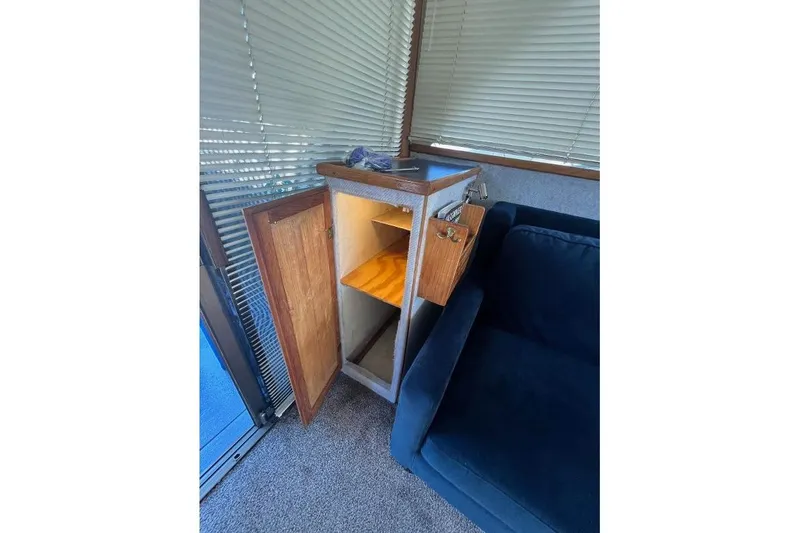 Slide: The Image of 1973 Uniflite Sport Fisher interior with open wooden cabinet and blue sofa. - 66