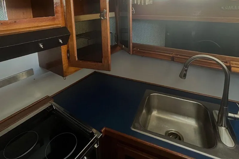 Slide: The Image of 1973 Uniflite Sport Fisher kitchen with sink, stove, and wooden cabinets. - 81