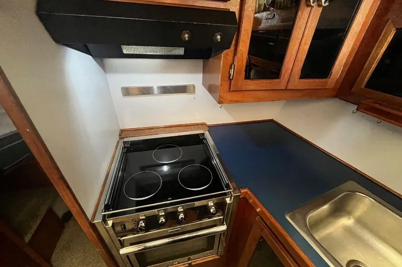 Slide: The Image of 1973 Uniflite Sport Fisher kitchen with stove, wooden cabinets, and stainless steel sink. - 85