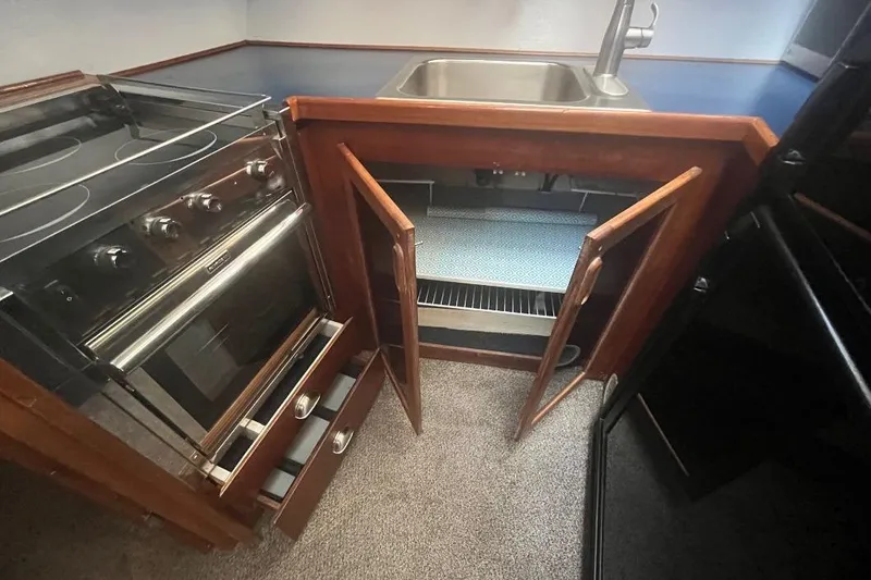 Slide: The Image of 1973 Uniflite Sport Fisher kitchen with stove, sink, and open cabinets. - 89