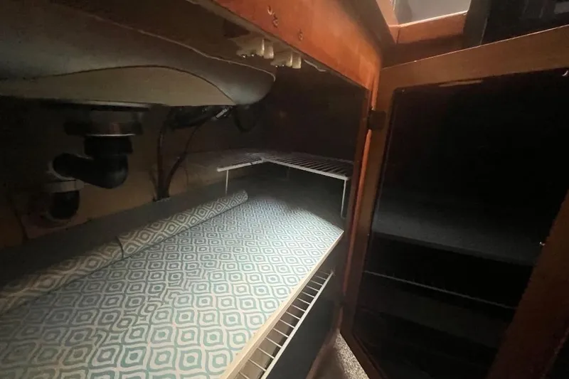 Slide: The Image of 1973 Uniflite Sport Fisher interior cabinet with patterned shelf liner and plumbing. - 90