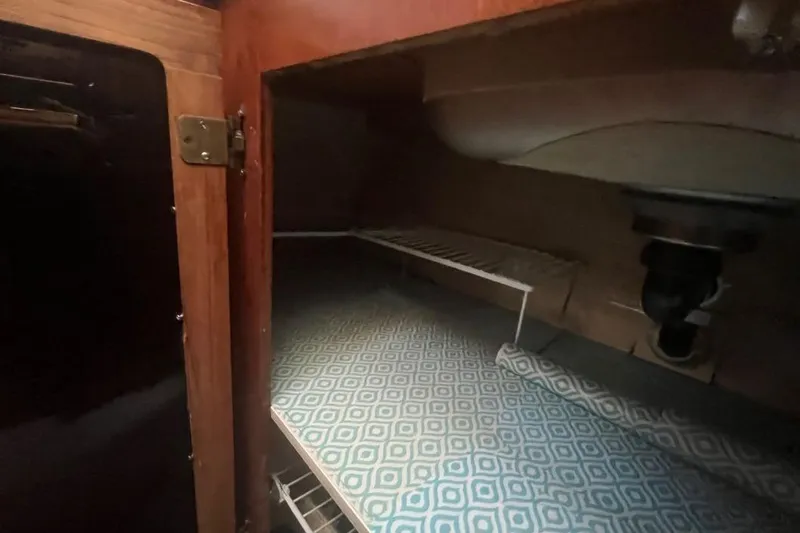 Slide: The Image of 1973 Uniflite Sport Fisher interior storage with patterned shelf liner and wooden cabinetry. - 91