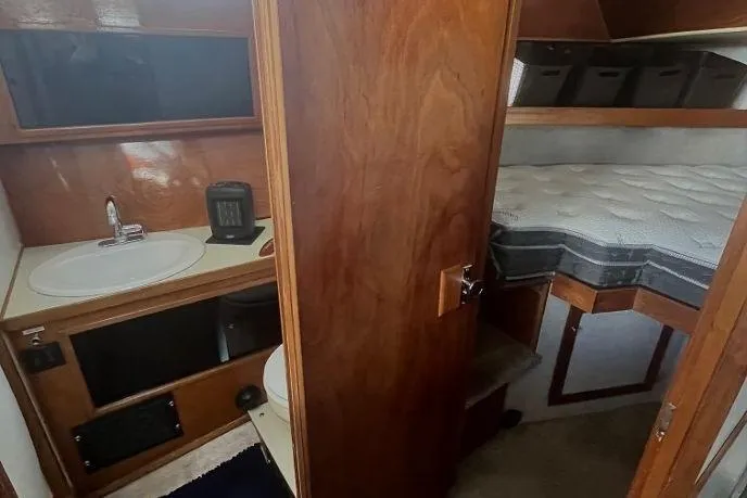 Slide: The Image of 1973 Uniflite Sport Fisher interior with wooden cabinetry, sink, and cozy sleeping area. - 93