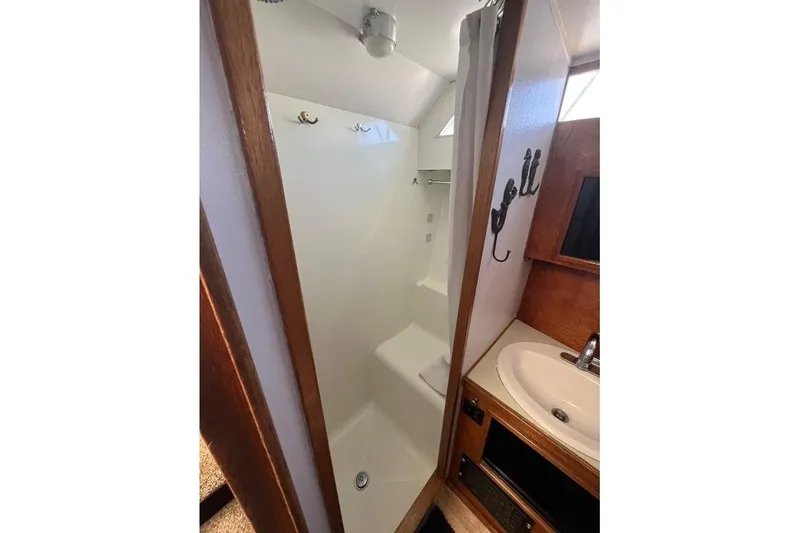 Slide: The Image of 1973 Uniflite Sport Fisher bathroom with shower, sink, and wooden accents. - 96