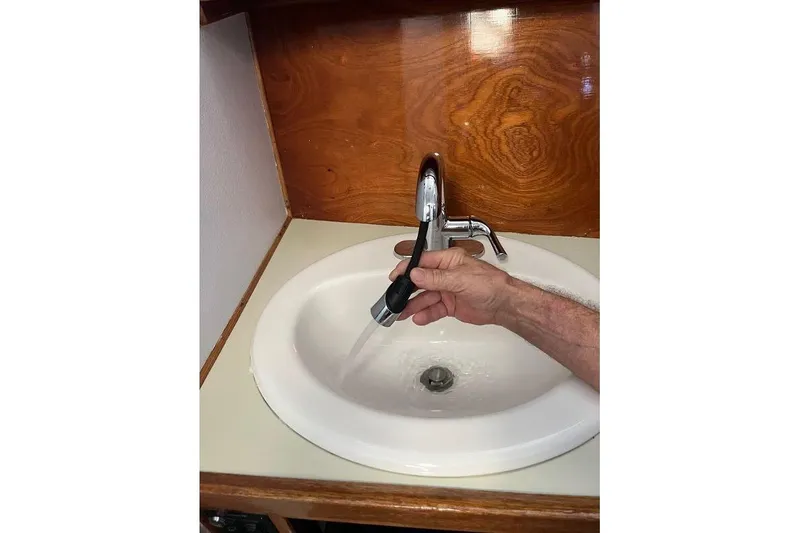 Slide: The Image of Hand using faucet in 1973 Uniflite Sport Fisher boat bathroom sink. - 97