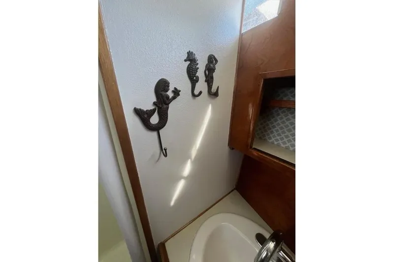 Slide: The Image of 1973 Uniflite Sport Fisher interior with mermaid wall hooks and wooden cabinetry. - 98