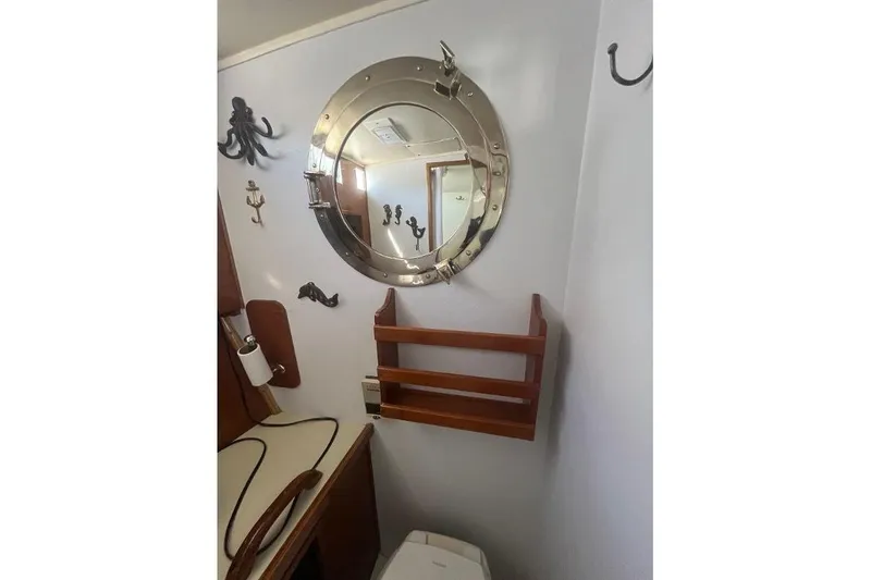 Slide: The Image of 1973 Uniflite Sport Fisher bathroom with nautical decor and porthole mirror. - 99