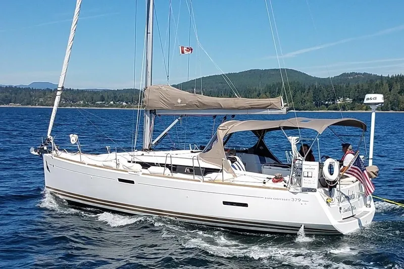 The Image of 2013 Jeanneau 379 sailboat cruising on a scenic lake with forested hills. - 0