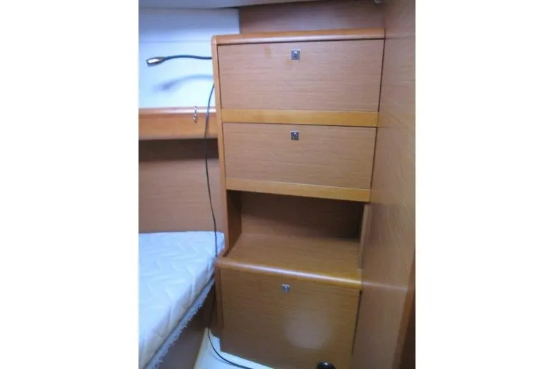 Slide: The Image of Interior cabin storage on 2013 Jeanneau 379 sailboat, featuring wooden drawers and a reading light. - 15