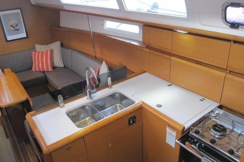 Slide: The Image of Interior of 2013 Jeanneau 379 sailboat with modern kitchen and cozy seating area. - 2