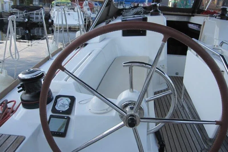 Slide: The Image of Steering wheel of a 2013 Jeanneau 379 sailboat in a marina setting. - 32
