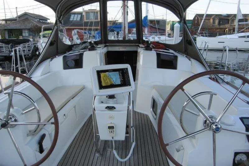 Slide: The Image of 2013 Jeanneau 379 sailboat cockpit with dual steering wheels and navigation equipment. - 33