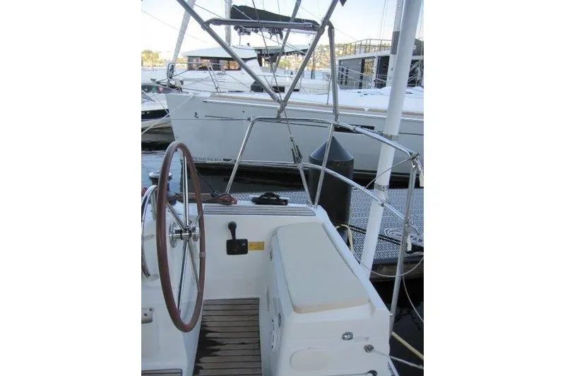 Slide: The Image of 2013 Jeanneau 379 sailboat cockpit with steering wheel and dock view. - 38