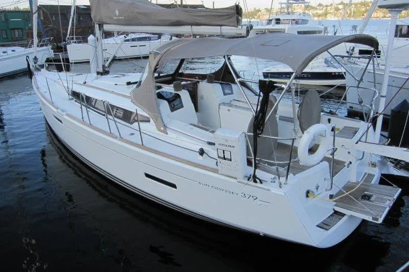 Slide: The Image of 2013 Jeanneau 379 sailboat docked in marina, featuring sleek design and spacious cockpit. - 49