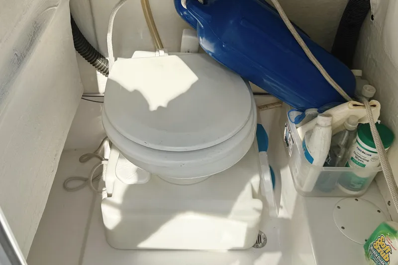 Slide: The Image of Boat toilet area with cleaning supplies on a 2015 Sportsman Heritage 231 Center Console. - 25
