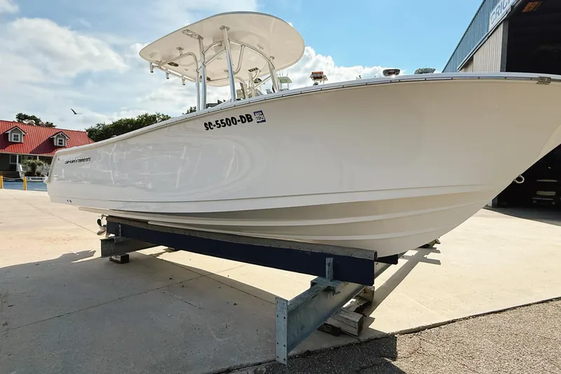 Slide: The Image of 2015 Sportsman Heritage 231 Center Console boat docked near a waterfront building. - 3