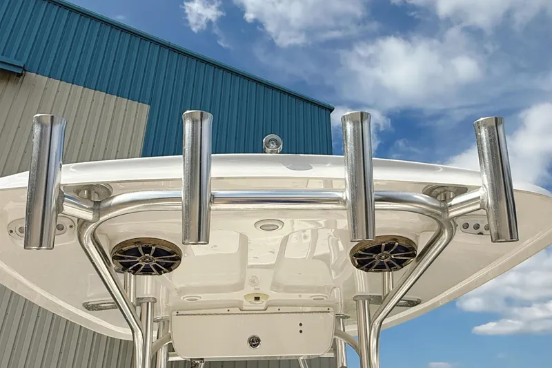 Slide: The Image of 2015 Sportsman Heritage 231 Center Console boat with rod holders and speakers under blue sky. - 30