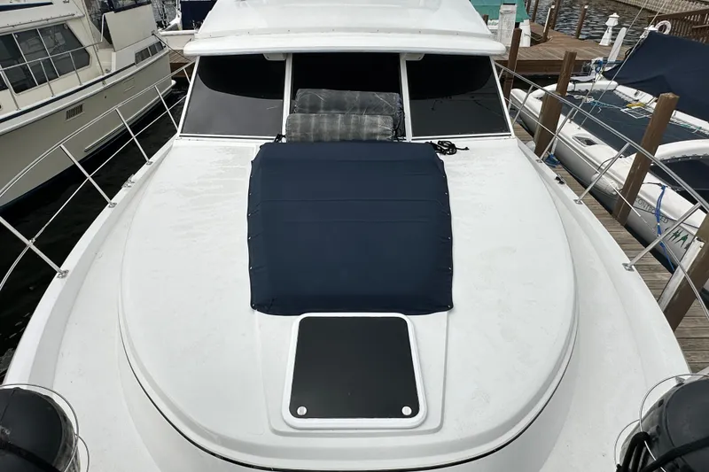 Slide: The Image of 1998 Carver 445 Aft Cabin Motor Yacht docked under cloudy skies. - 16