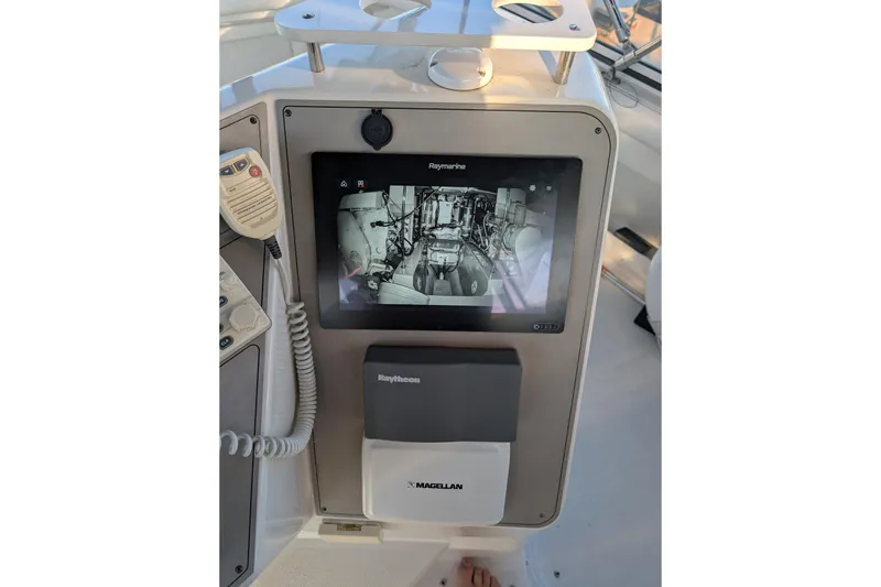 Slide: The Image of 1998 Carver 445 Aft Cabin Motor Yacht helm with steering wheel and controls, dockside view. - 34